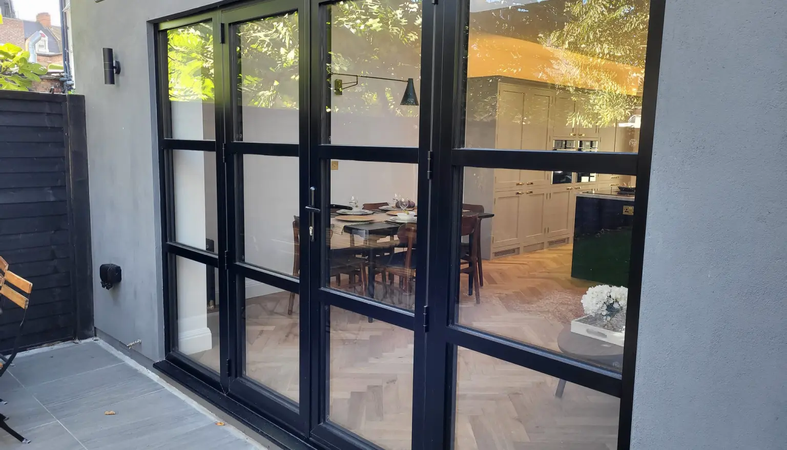 Photo of a closeup aluminium and glass doorway from the garden of a house 