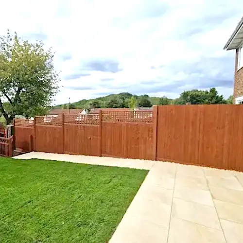 Photo of green grass landscaped garden with wooden fencing